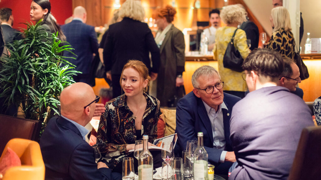 Menschen sitzen und stehen zusammen bei einem Event