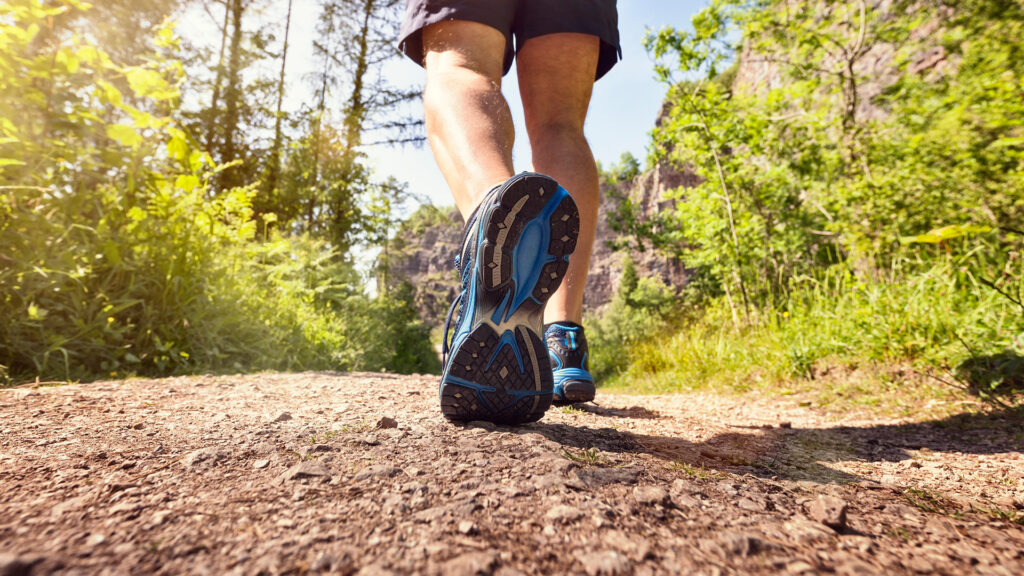 Mann joggt oder wacht im Freien auf einem Fußweg oder Pfad Konzept für gesunden Lebensstil, Sport ausüben, laufen und Fitness