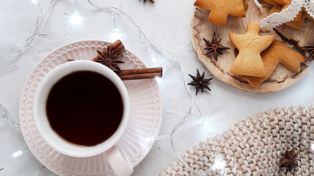 weihnachtlich gedeckter Kaffeetisch mit Dekoration, weißer Decke, Plätzchen und Anis und Zimt