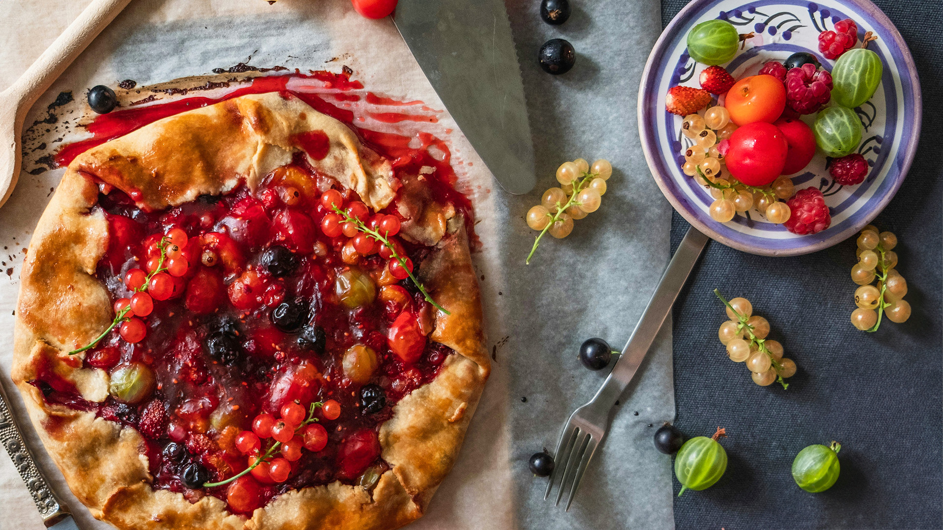 verschiedene Beeren auf einen Teller und einem Kuchen, sehr bunt und schmackhaft